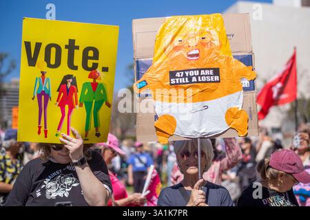 Los Angeles, Usa. März 2025. Die Demonstranten halten Plakate, während sie sich auf die Straßen der Innenstadt von Los Angeles begeben, um den Frauenmarsch in Los Angeles zu feiern. Quelle: SOPA Images Limited/Alamy Live News Stockfoto