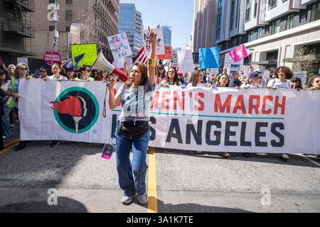 Los Angeles, Usa. März 2025. Ein Demonstrant führt Kollegen an, während sie zum Frauenmarsch in Los Angeles auf die Straßen der Innenstadt von Los Angeles gehen. Quelle: SOPA Images Limited/Alamy Live News Stockfoto