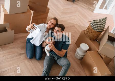 Das Appartement sieht man an. Ein junges Paar mit Hund zieht in ein neues Zuhause. Stockfoto