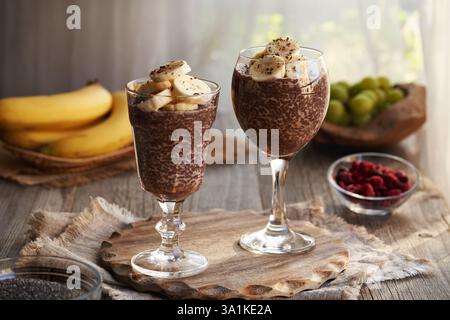 Zwei Tassen gesunder Chia-Schokoladenpudding mit frisch geschnittenen Bananen Stockfoto