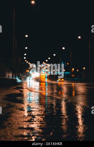 Regnerische Nachtstraße mit reflektierenden Autolichtern auf nassem Asphalt Stockfoto