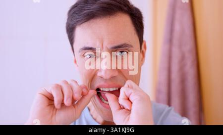 Mann, der Zähne im Bad flossiert, Mundhygiene-Routine Stockfoto
