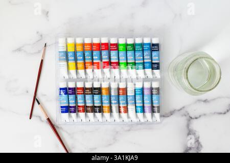 Aquarellfarben Set, Papier, Pinsel, Bleistifte in Nahaufnahme auf einem Tisch, flache Lagen Stockfoto