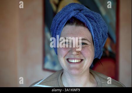 Porträt einer lachenden jungen Frau, das Handtuch um den Kopf gewickelt wie ein Turban, Bayern, Deutschland, Europa Stockfoto