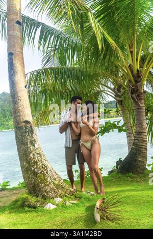 Touristen, die sich unter Palmen auf Kawhagan Island, Siargao, philippinen umziehen, genießen einen romantischen Moment während ihres tropischen Urlaubs Stockfoto