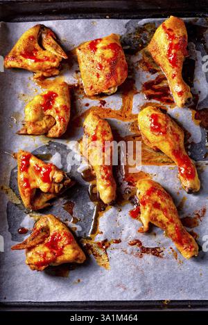 Rustikale Hähnchenflügel mit Rücken, Beine auf Backblech Stockfoto