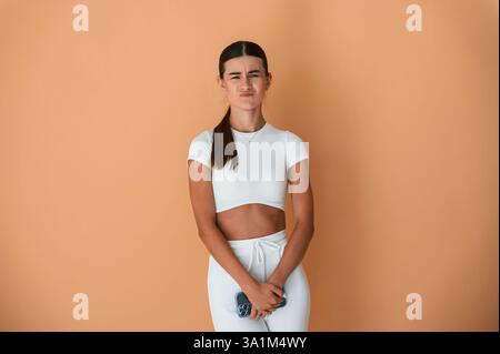 Ich mag nichts, unglücklich. Schöne junge Frau in weißen Kleidern steht drinnen. Stockfoto