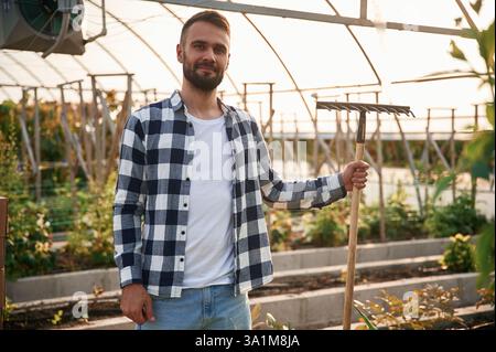 Der junge Gärtner ist im Gewächshaus. Stockfoto