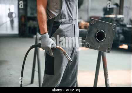 Halten von Schweißgeräten. Nahaufnahme eines Mannes, der in der Fabrik arbeitet. Stockfoto