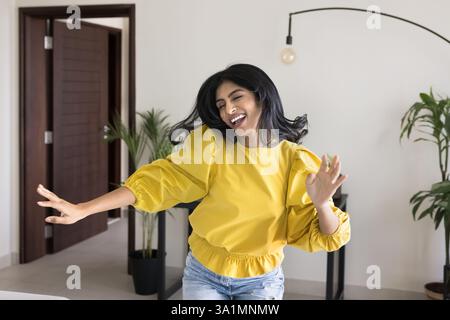 Junge 30er-Indianerin, die zu Hause tanzt Stockfoto