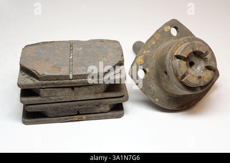 Rostiges Kugelgelenk des Autos und Haufen verschlissener Bremsbeläge, Ersatzteile, die durch Wartung aus dem Fahrzeug zerlegt wurden Stockfoto