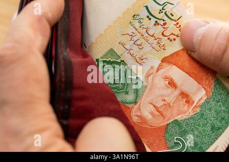 Pakistanische Rupien nehmen aus einer Brieftasche Stockfoto