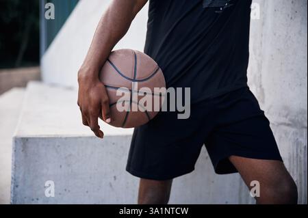 Nahansicht. Der junge Schwarze ist draußen mit Basketball. Stockfoto