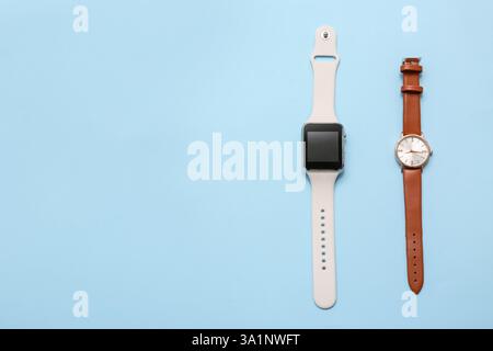 Armbanduhr und moderner Sportsensor auf blauem Hintergrund. Evolutionskonzept Stockfoto