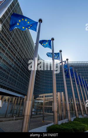 Europäische Fahnen, Symbole der Europäischen Union (EU), flattern gegen das Berlaymont-Gebäude, Sitz der Europäischen Kommission in Brüssel Stockfoto