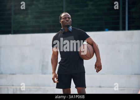 Den Ball in den Händen halten. Junger schwarzer Mann. Stockfoto