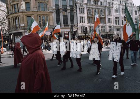 Handmaids Tale Protest in London am Internationalen Frauentag, 8. März 2024, marschierten britisch-iranische Frauen, organisiert von der Gruppe Stage of Freedom, schweigend durch das Zentrum Londons, gekleidet in roten Mänteln und weißen Hauben, die an die Handmaids Tale erinnern. Die Prozession begann am Parlamentsplatz und endete in der iranischen Botschaft in Kensington. Die Teilnehmer trugen Plakate von Demonstrantinnen, die seit Beginn der Mahsa-Proteste im September 2022 vom iranischen Regime getötet, verletzt oder inhaftiert worden waren, ausgelöst durch den Tod der 22-jährigen Mahsa Amini während der Haft der Irans Mora Stockfoto