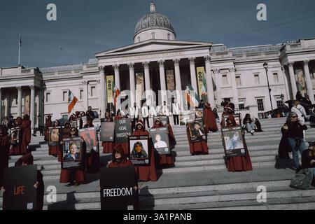 Handmaids Tale Protest in London am Internationalen Frauentag, 8. März 2024, marschierten britisch-iranische Frauen, organisiert von der Gruppe Stage of Freedom, schweigend durch das Zentrum Londons, gekleidet in roten Mänteln und weißen Hauben, die an die Handmaids Tale erinnern. Die Prozession begann am Parlamentsplatz und endete in der iranischen Botschaft in Kensington. Die Teilnehmer trugen Plakate von Demonstrantinnen, die seit Beginn der Mahsa-Proteste im September 2022 vom iranischen Regime getötet, verletzt oder inhaftiert worden waren, ausgelöst durch den Tod der 22-jährigen Mahsa Amini während der Haft der Irans Mora Stockfoto