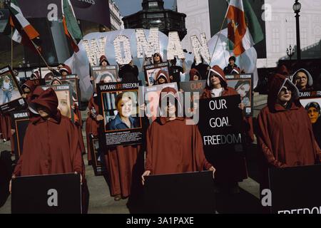 Handmaids Tale Protest in London am Internationalen Frauentag, 8. März 2024, marschierten britisch-iranische Frauen, organisiert von der Gruppe Stage of Freedom, schweigend durch das Zentrum Londons, gekleidet in roten Mänteln und weißen Hauben, die an die Handmaids Tale erinnern. Die Prozession begann am Parlamentsplatz und endete in der iranischen Botschaft in Kensington. Die Teilnehmer trugen Plakate von Demonstrantinnen, die seit Beginn der Mahsa-Proteste im September 2022 vom iranischen Regime getötet, verletzt oder inhaftiert worden waren, ausgelöst durch den Tod der 22-jährigen Mahsa Amini während der Haft der Irans Mora Stockfoto