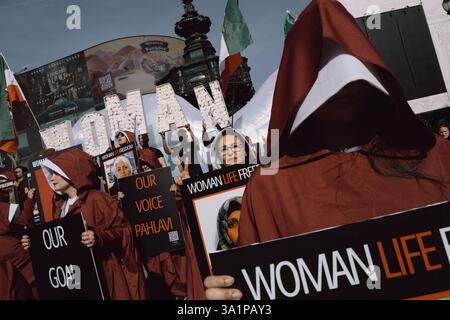 Handmaids Tale Protest in London am Internationalen Frauentag, 8. März 2024, marschierten britisch-iranische Frauen, organisiert von der Gruppe Stage of Freedom, schweigend durch das Zentrum Londons, gekleidet in roten Mänteln und weißen Hauben, die an die Handmaids Tale erinnern. Die Prozession begann am Parlamentsplatz und endete in der iranischen Botschaft in Kensington. Die Teilnehmer trugen Plakate von Demonstrantinnen, die seit Beginn der Mahsa-Proteste im September 2022 vom iranischen Regime getötet, verletzt oder inhaftiert worden waren, ausgelöst durch den Tod der 22-jährigen Mahsa Amini während der Haft der Irans Mora Stockfoto