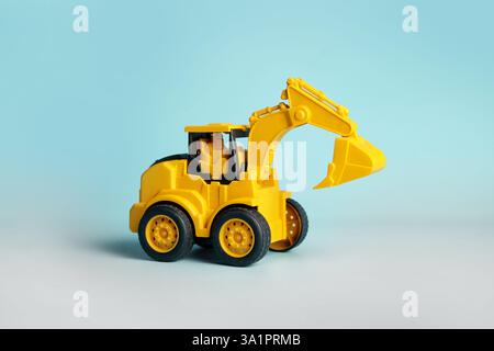 Gelbes Mini-Bagger-Spielzeug in Aktion Stockfoto