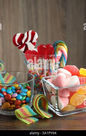 Schokoriegel. Viele verschiedene leckere Süßigkeiten auf Holztisch Stockfoto