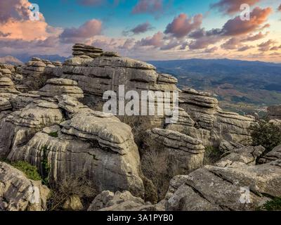 Kalksteinfelsen, die in interessanten Formationen übereinander gestapelt sind, am El Torcal de Antequera Sapin, dem Sonnenuntergangshimmel Stockfoto