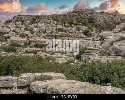 Kalksteinfelsen, die in interessanten Formationen übereinander gestapelt sind, am El Torcal de Antequera Sapin, dem Sonnenuntergangshimmel Stockfoto