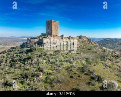 Aus der Vogelperspektive auf das Schloss Feria in Spanien, gotische und Mudéjar-Gebäude, einen quadratischen Donjon, einen Hintergrund mit blauem Himmel Stockfoto