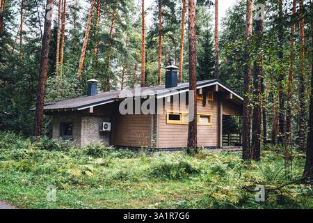 Sonnig von einem schönen einstöckigen, hölzernen Haus mit grünem Garten an sonnigen Sommertagen Stockfoto