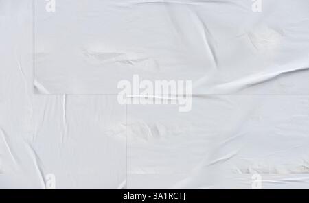 Weißer, zerknitterter und gefalteter Papierhintergrund. Leerer weißer, zerknitterter und gefalteter Aufkleber mit Poster-Textur Stockfoto