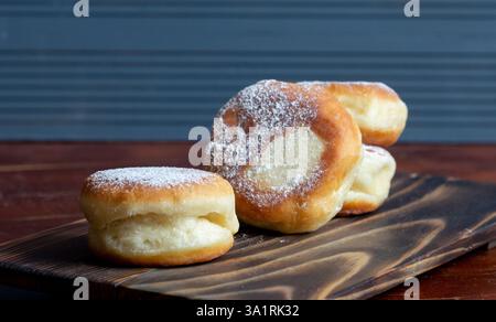 Berliner Donuts mit Erdbeermarmelade in Nahaufnahme auf einem Holzständer Stockfoto