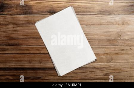 Leeres Papier auf Holztisch. Leeres leeres weißes Grunge-Papier auf heller Eiche Holztischplatte, Ansicht von oben. Blatt leeres Notizpapier Stockfoto