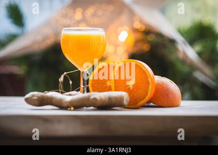 Ingwerschuss mit frischen Orangen und Ingwerwurzel auf rustikalem Tisch Stockfoto