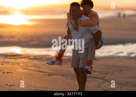 Glückliches Paar beim Sonnenuntergang am Strand Stockfoto