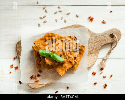 Glutenfreie Knäckebrot aus Buskweizenmehl. Grünes Buchweizenmehl geräuchertes Paprika Sonnenblumenkerne Zutaten hausgemachtes, gebackenes Knäckebrot. Idee Rezept Snacks glutenfreies Konzept. Draufsicht flach liegend Stockfoto