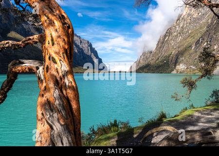 Ein atemberaubender türkisfarbener See reflektiert den blauen Himmel, eingebettet zwischen hoch aufragenden Bergen. Die friedliche Landschaft ist Teil der berühmten Laguna 69 Trek in Hu Stockfoto