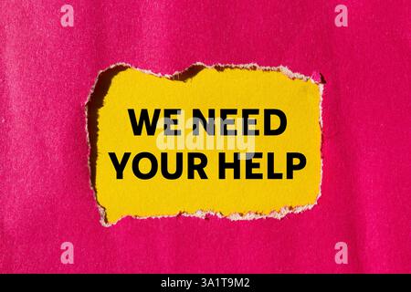 Wir brauchen Ihre Hilfe auf gerissenem rosafarbenem Papier auf gelbem Hintergrund. Konzeptionell brauchen wir Ihr Hilfesymbol. Kopierbereich. Stockfoto