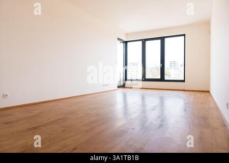 Modernes leeres Zimmer mit großen, schwenkbaren Fenstern und Holzfußboden Stockfoto