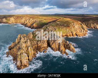 Luftaufnahme von Treryn Dinas Landzunge und Logan Rock bei Porthcurno an der Westküste von Cornwall, England. Winter (Januar) 2025. Stockfoto