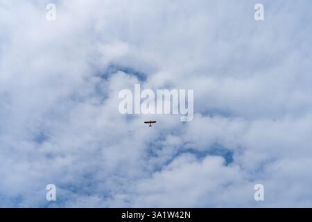 Vintage-Flugzeug gleitet durch den bewölkten Himmel von La Roche-Guyon in einer ruhigen Nachmittagsatmosphäre Stockfoto