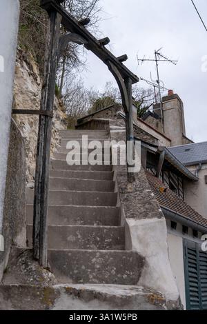 Bezaubernde Steintreppen, die an einem bewölkten Tag durch das historische La Roche-Guyon führen, laden zur Erkundung und Entdeckung versteckter Wege ein Stockfoto