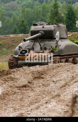 Ein amerikanischer M4A1 Sherman Panzer aus dem Zweiten Weltkrieg steht auf einem Feld im Regen und Schlamm. Stockfoto