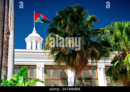 Weißes Gebäude des Museums Caracas und Caracas Stadtflagge Venezuela. Ein tropisches Land mit Palmen. Stockfoto