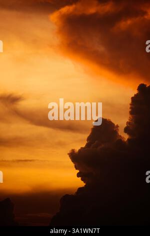 Dunkle Wolken türmen sich vor einem lebendigen Sonnenuntergang Stockfoto