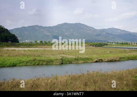 Namwon City, Südkorea - 3. Oktober 2021: Ein ruhiger Blick auf den Seomjin River, der sich durch üppige Feuchtgebiete schlängelt, mit einer Kulisse aus bewaldeten Bergen Stockfoto