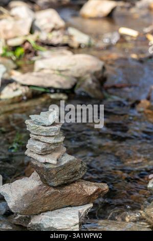 Gleichgewichtssteine in einem Bachlauf im Frühling spirituelle Entspannung vertikal Stockfoto