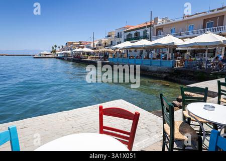 Holzstühle und -Tisch in der am Wasser gelegenen griechischen Taverne, Koroni, Messenia, Peloponnes, Griechenland, Europa Stockfoto