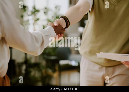 Mittlere Nahaufnahme einer nicht erkennbaren Bewerberin und Personalverantwortlichen, die höflich die Hände schütteln Stockfoto