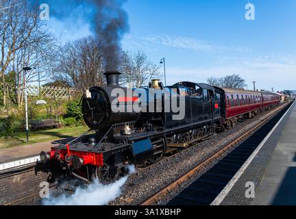 Black Steam Train Lokomotive fährt aus einem Bahnhof, Lokomotivzugwagen aus dem Bahnhof, altes Transportkonzept Stockfoto